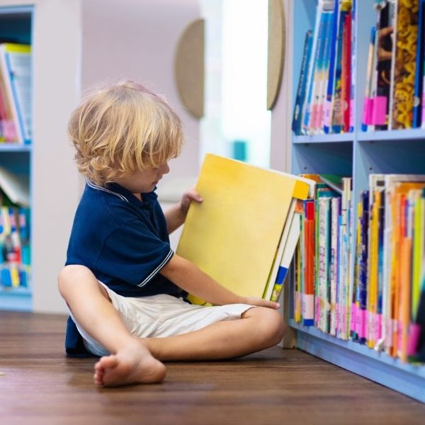 child choosing a book to read from a bookcase.jpg