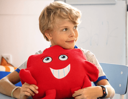 A blonde boy holding a Jigsaw characyer
