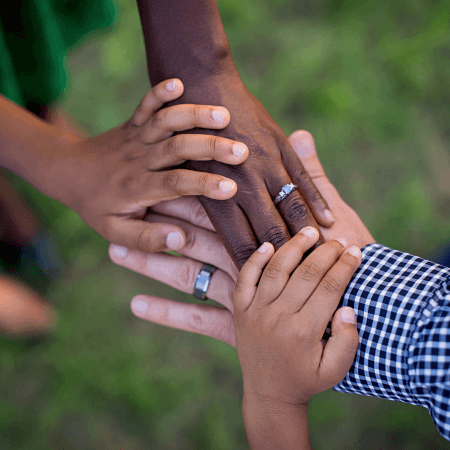A group of hands on top of each other close up