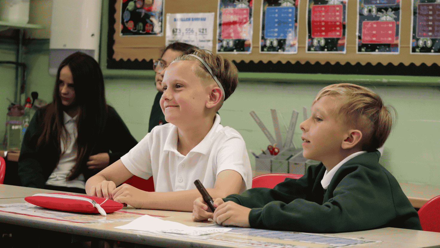 Two boys in a classroom smiling together
