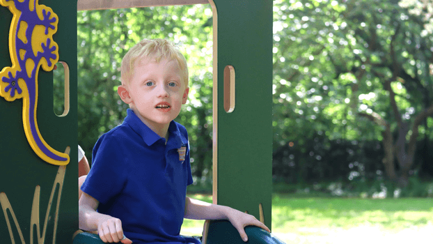 Boy sitting on a slide in a playpark