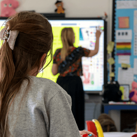 Teacher in a classroom using interactive screen
