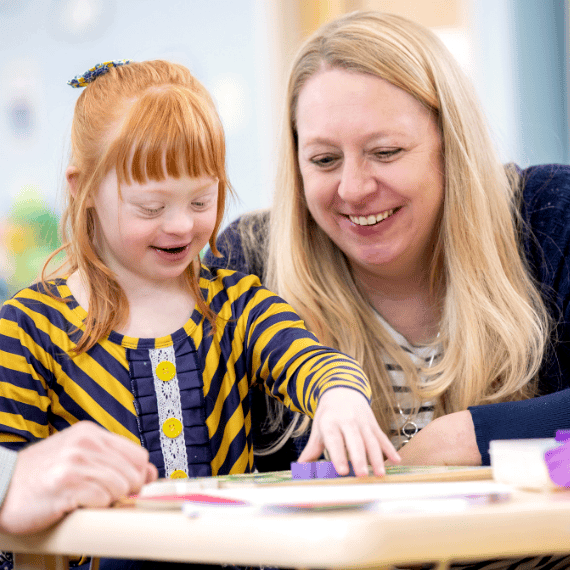 Teacher helping child in classroom