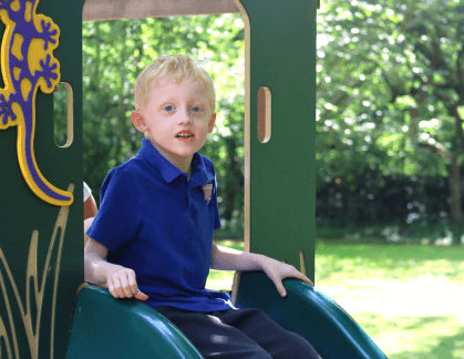 Boy sitting on a slide in a playpark