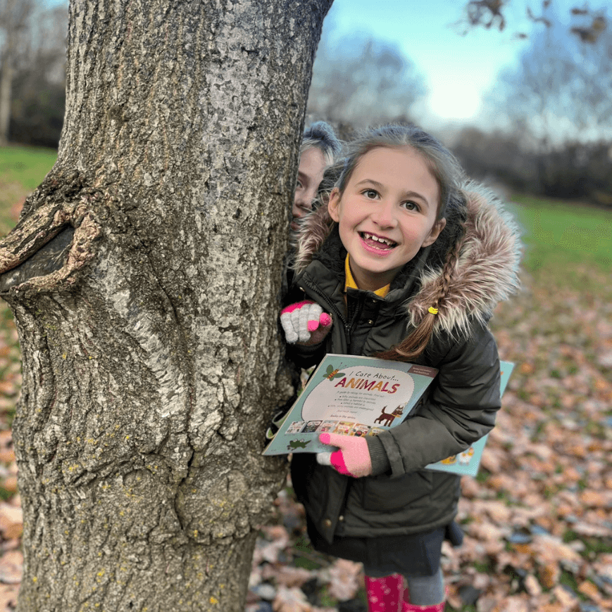 Girl smiling next to a tree