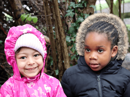 Two children smiling outdoors