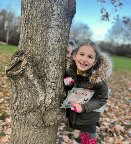 Girl smiling next to a tree