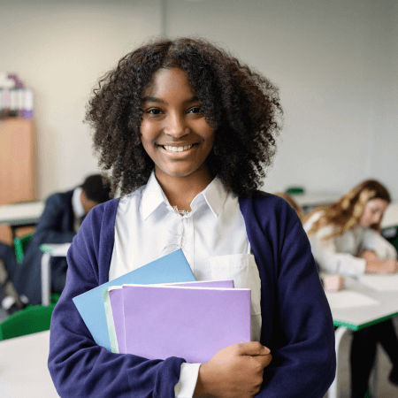 A secondary school girl standing smiling