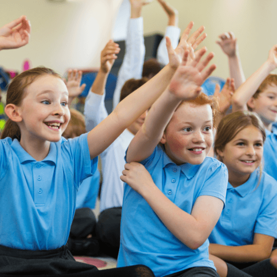 Children with hands up in lesson