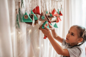 a girl handing up advent decorations